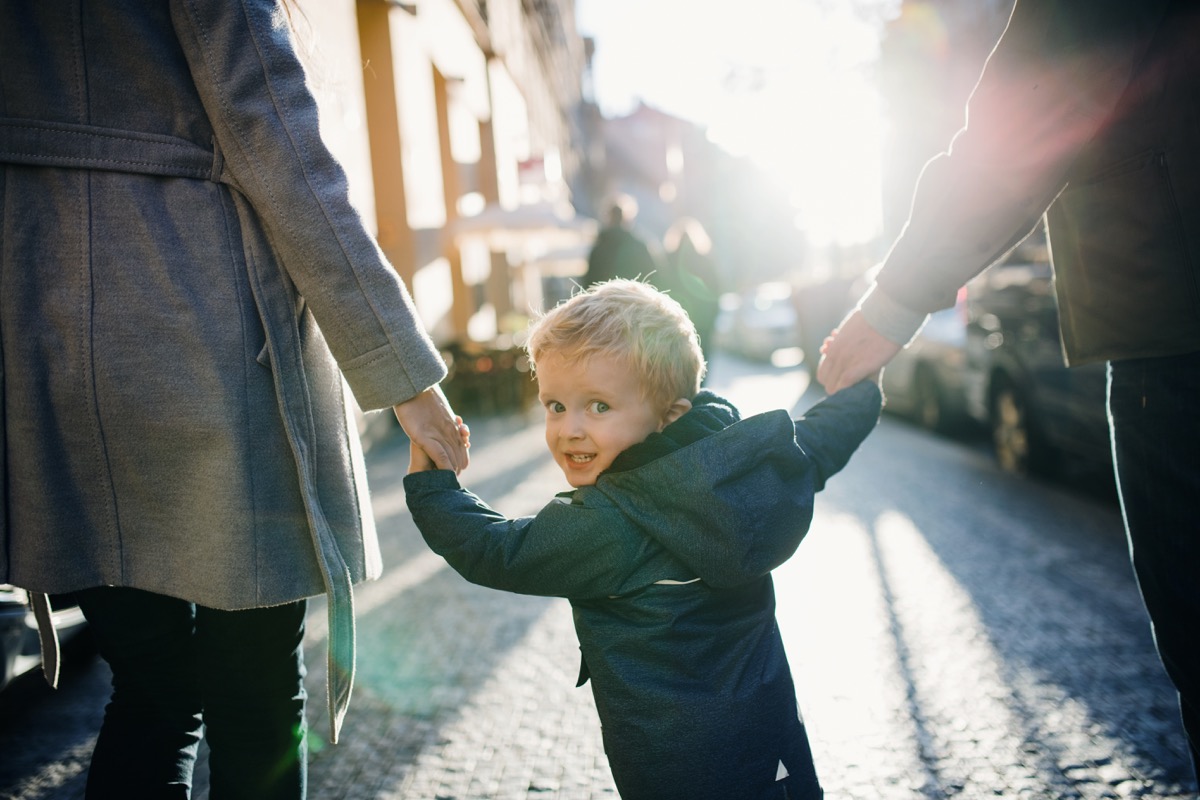 parents holding hands with their kid