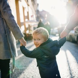 parents holding hands with their kid