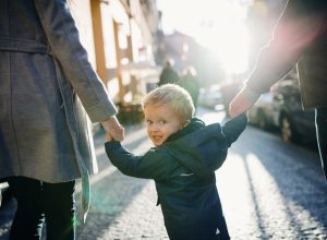 parents holding hands with their kid
