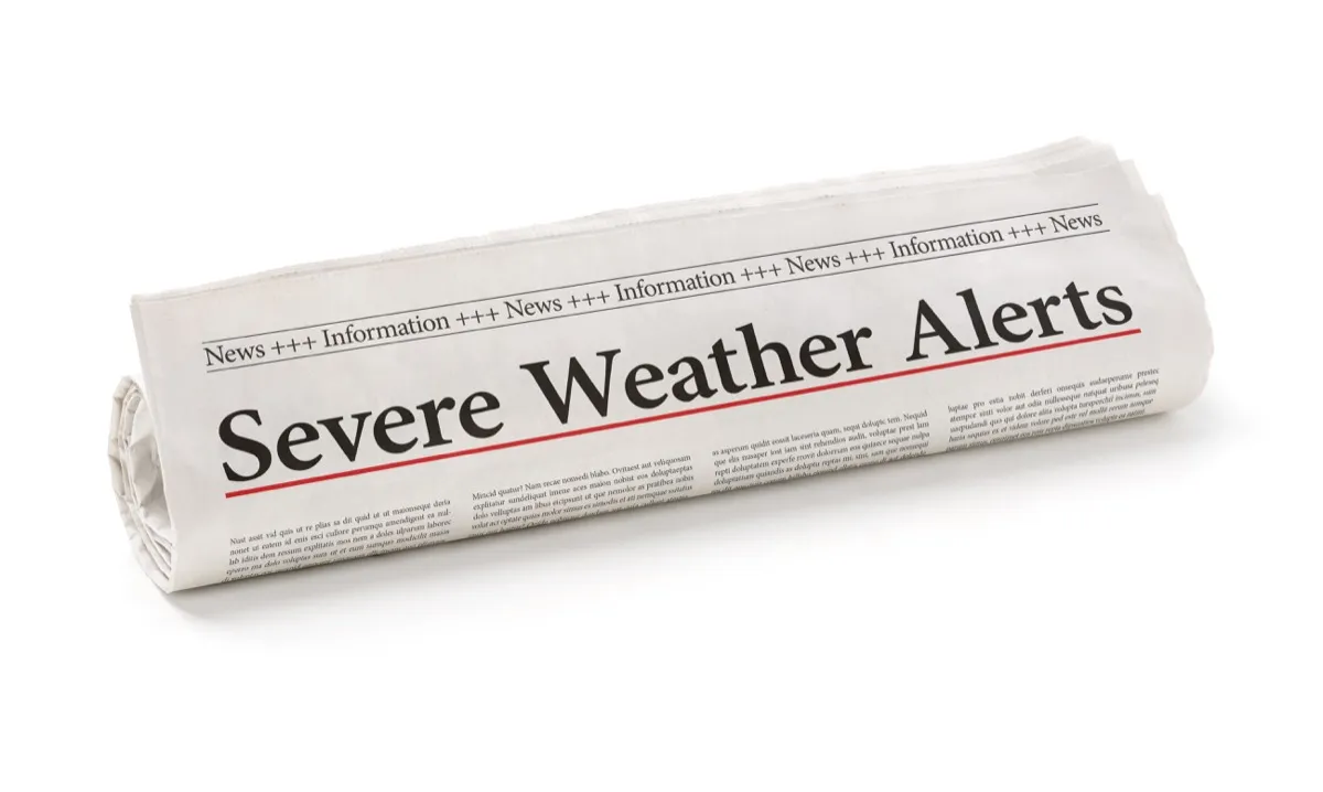Rolled newspaper with the headline Severe Weather Alerts