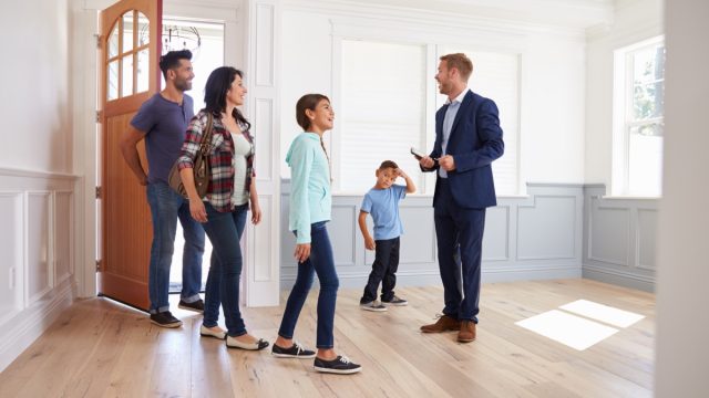 Real Estate Agent Showing a Family a House {Cons of Owning a Big House}