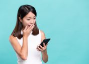 shocked woman looking at a phone against a light blue background, did you know facts