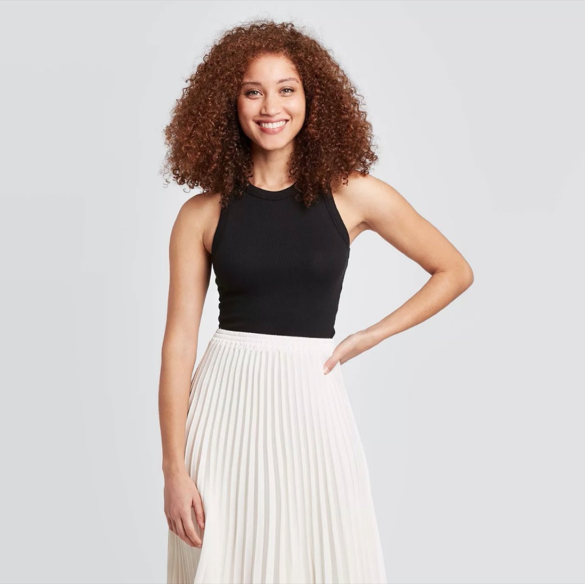 young woman in black tank top and white skirt