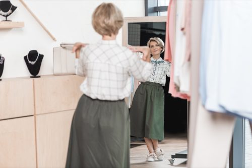 Woman looking at her outfit in the mirror
