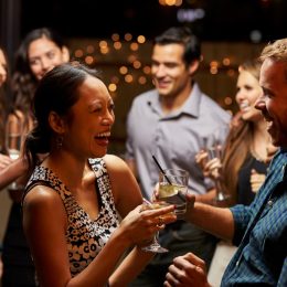 woman and man laughing in conversation at a cocktail party, bad jokes