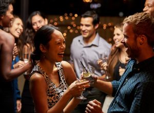 woman and man laughing in conversation at a cocktail party, bad jokes