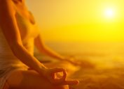 woman meditating at sunset