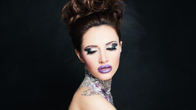 woman wearing fake eyelashes and tacky glittery bright makeup