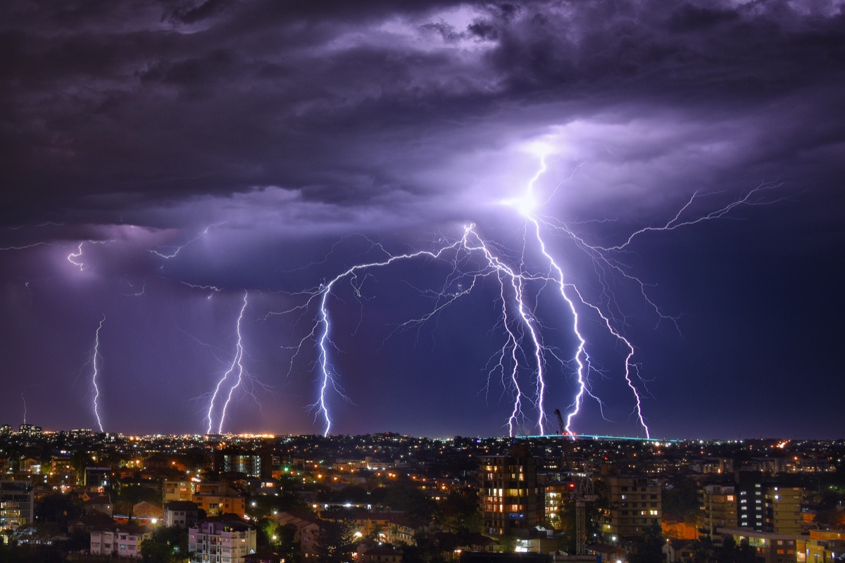 Lightning storm at night amid purple sky in Brisbane City
