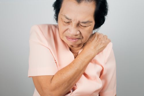 Asian woman suffering from shoulder pain