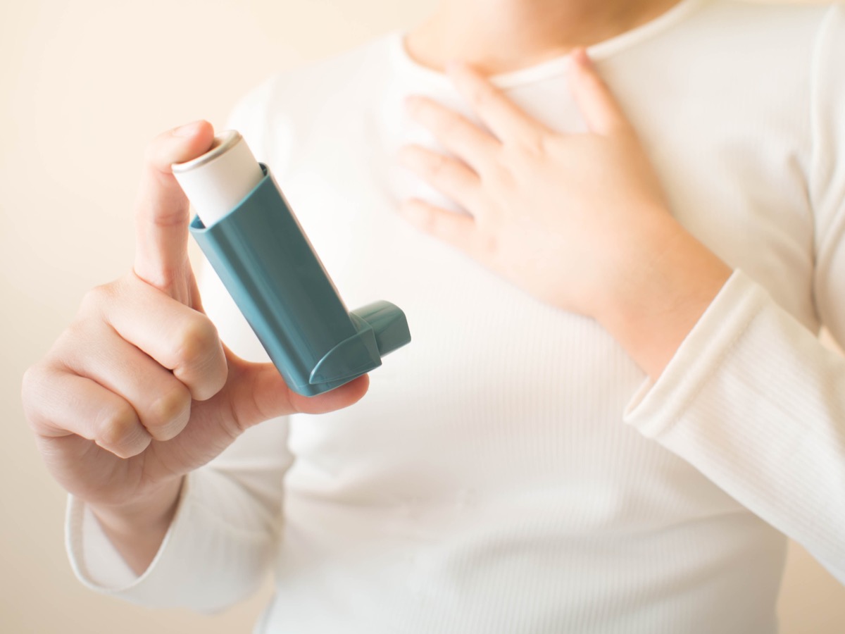 woman holding asthma inhaler, parenting is harder