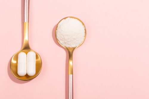 Collagen powder and pills on pink background. Extra protein intake. Natural beauty and health supplement for skin, bones, joints and gut. Plant or fish based. Flatlay, top view. Copy space text. - Image