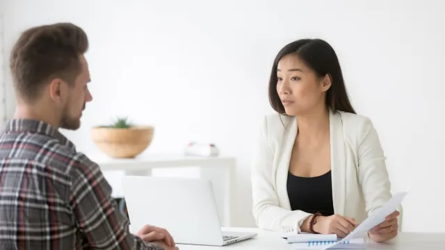 man talking to asian woman at job interview