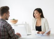 man talking to asian woman at job interview