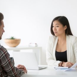 man talking to asian woman at job interview