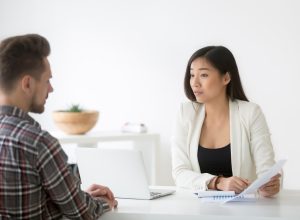 man talking to asian woman at job interview