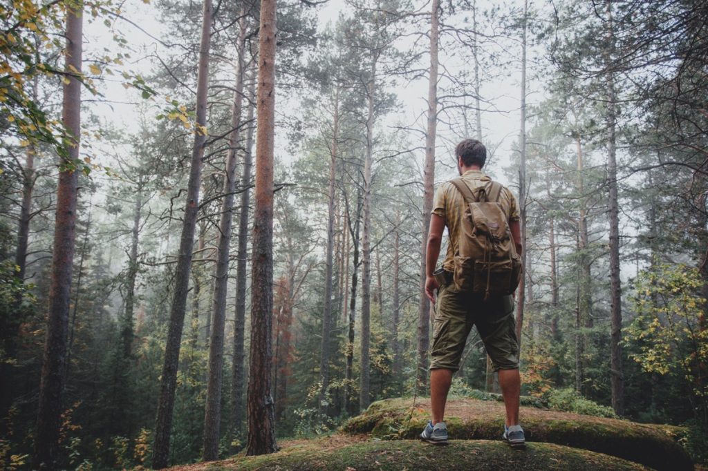 man backpacking through the woods alone