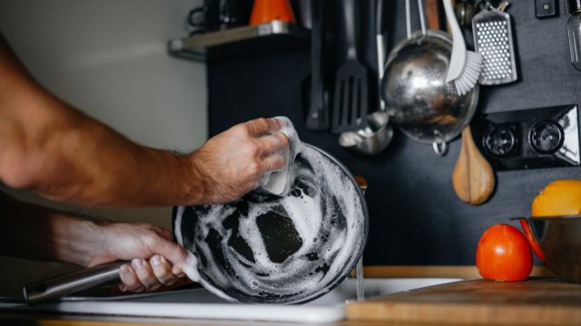 man hand-washing a cast iron pan, new uses for cleaning products