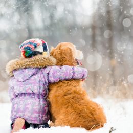 little girl hugging dog in winter, skills parents should teach kids