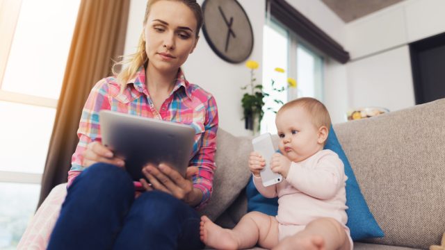 woman reads tablet, stay at home mom
