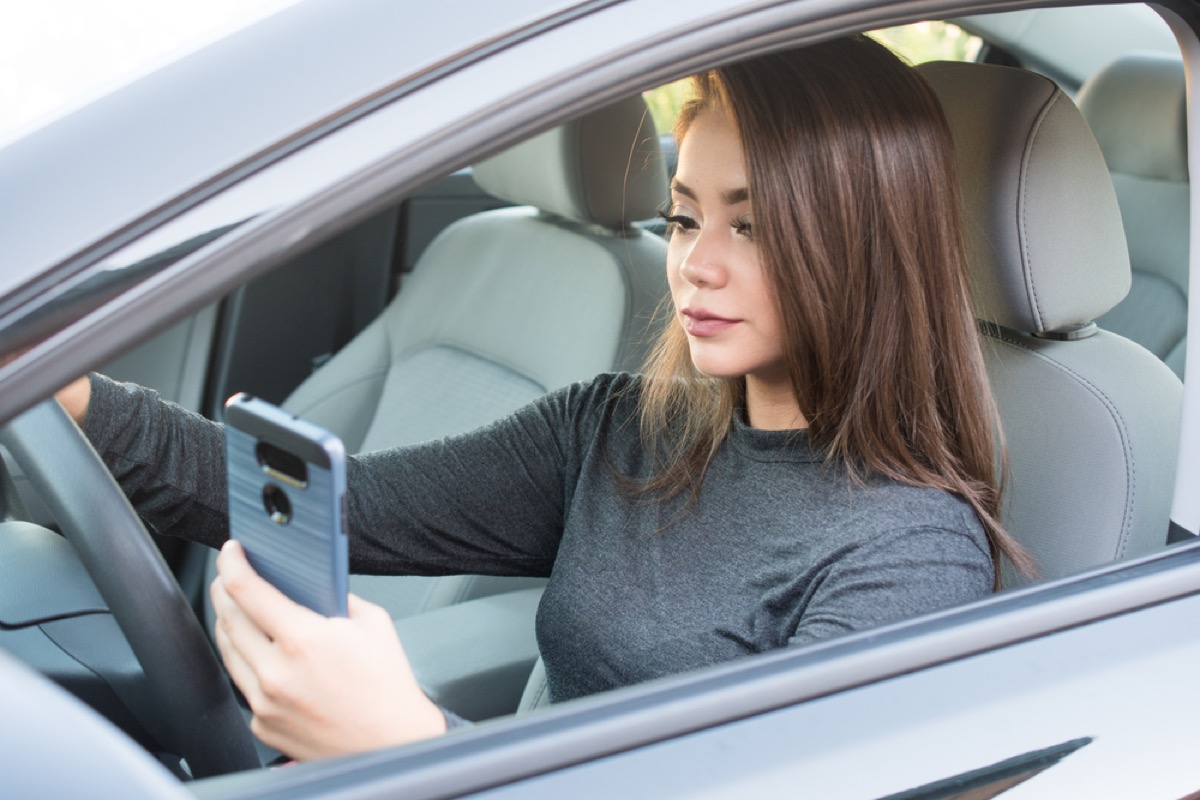 teen girl texting in driver's seat of car, parenting is harder