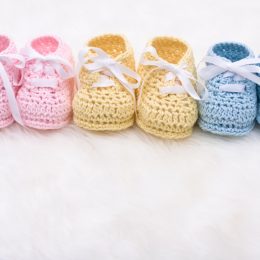 Three pairs of baby shoes, representing three children