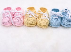 Three pairs of baby shoes, representing three children