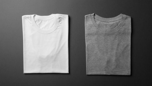 a white t shirt and a grey t shirt folded next to each other on a black background