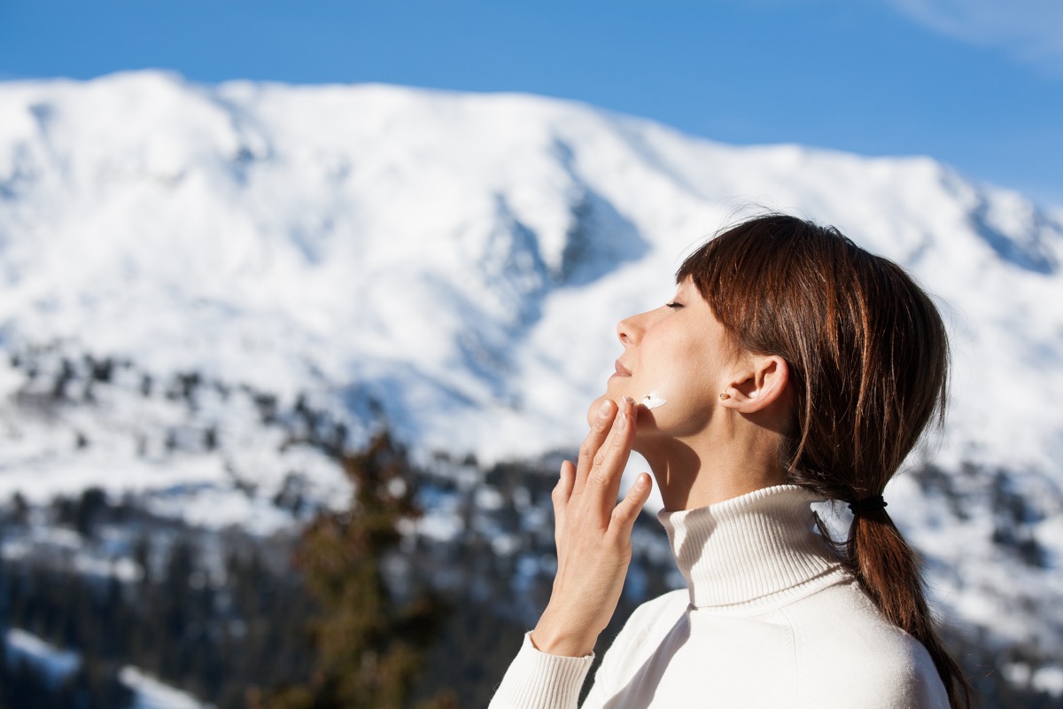 Woman applying sunscreen during winter