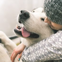 woman squeezing happy dog
