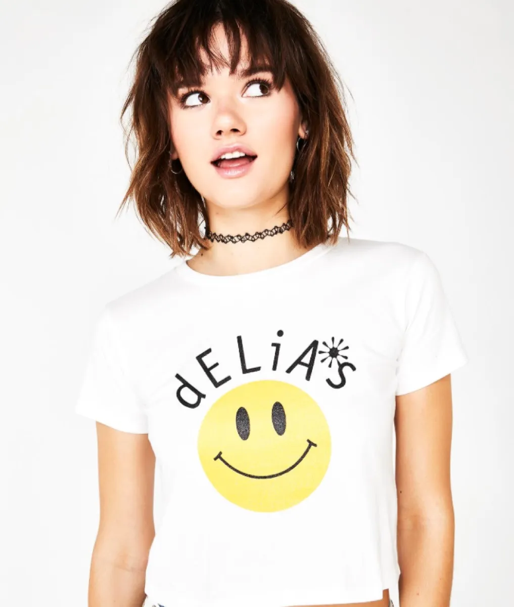 girl with choker necklace and white delias baby tee with smile face, a 90s fashion trend