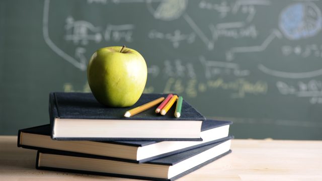 apple on a teacher's desk with books, best teacher gift ideas