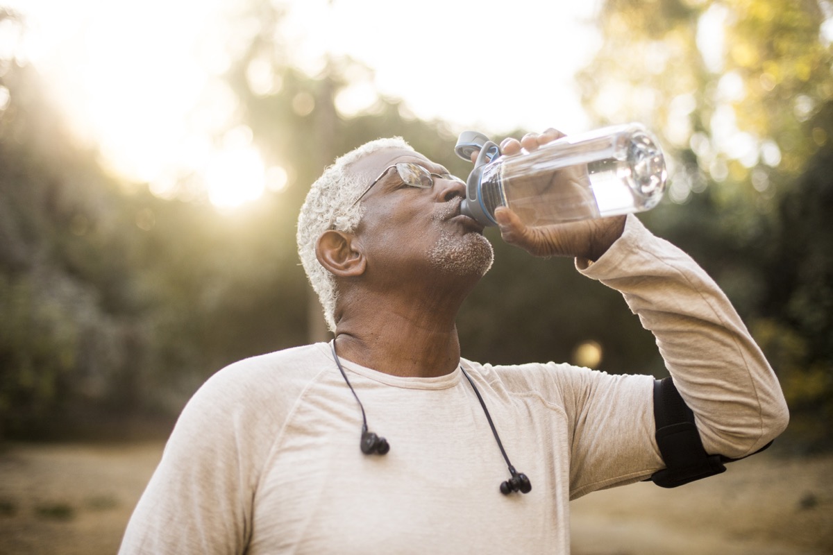 A senior African American Man enjoying refreshing water after a workout