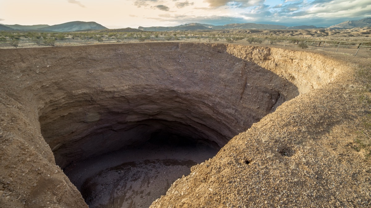 wet cavernous hole in death valley amid desert backdrop, state fact about nevada