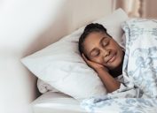 middle aged black woman sleeping soundly while smiling a bit