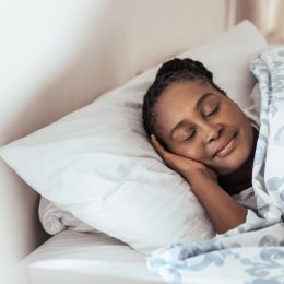 middle aged black woman sleeping soundly while smiling a bit