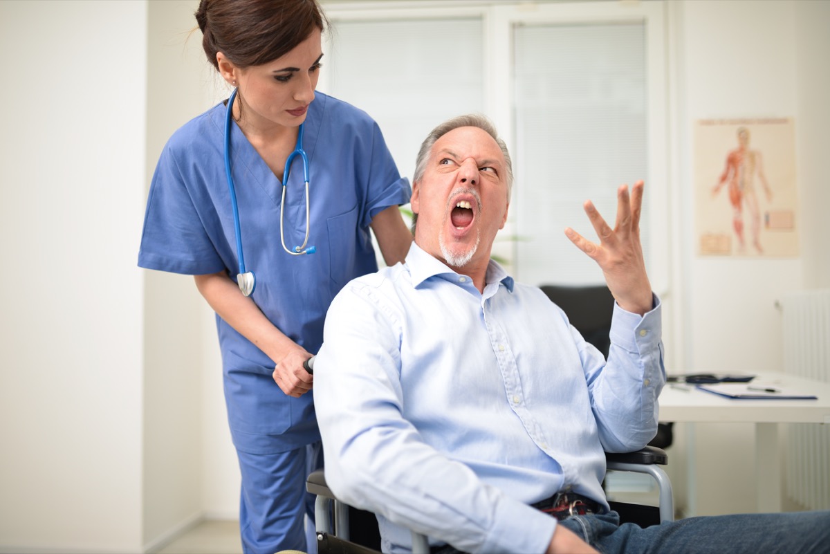 Senior man in a wheelchair yelling at the doctor