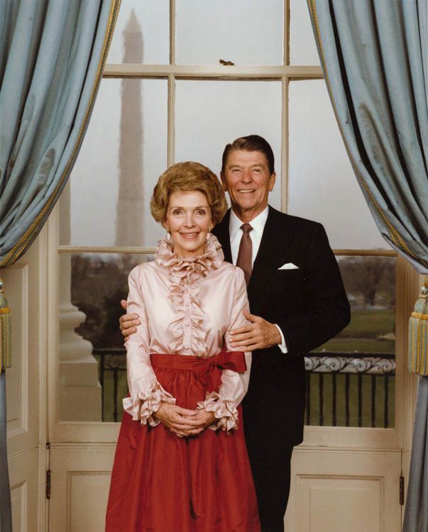 President Reagan and Mrs. Reagan pose in the Blue Room for their official portrait, nancy wearing ruffled shirt, 1980s fashion