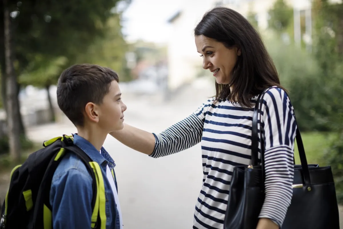 small child talking to mom in front of school