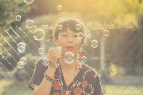 Adult asian woman blowing bubbles