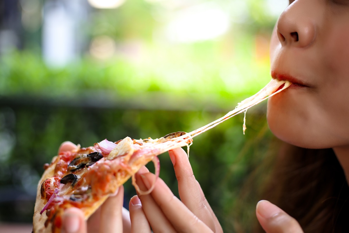 woman eating pizza, healthy sex after 40