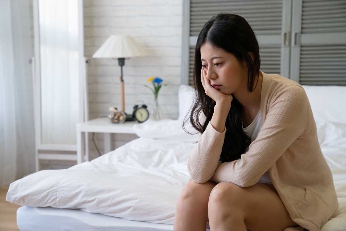 Woman looking sad and depressed in bed