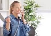young blonde woman talking on corded home phone