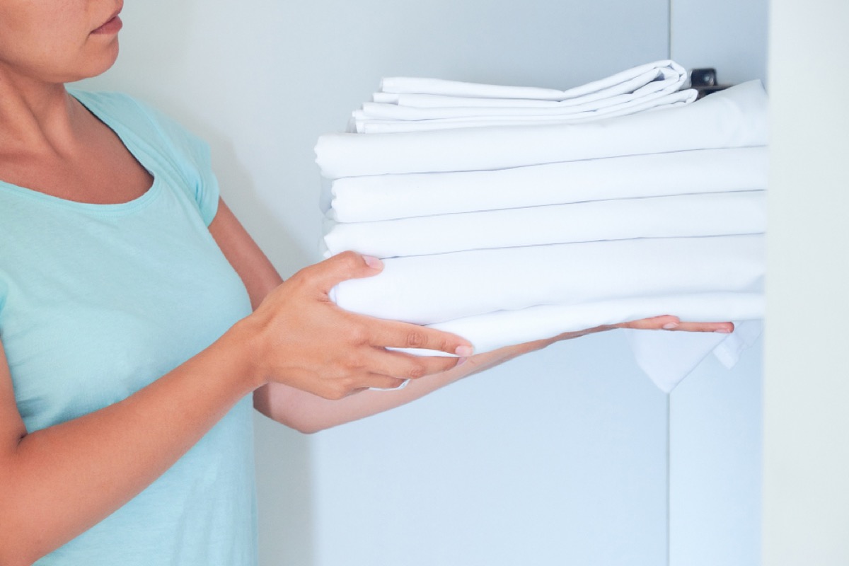 woman holding pile of sheets, health changes after 40
