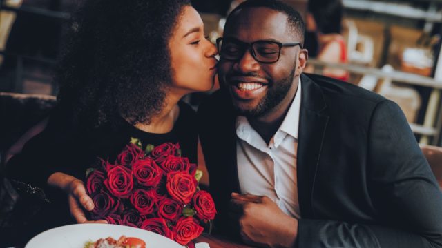 Black couple at restaurant with roses