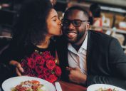 Black couple at restaurant with roses