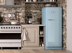 product shot of a baby blue full-size SMEG fridge in a rustic kitchen