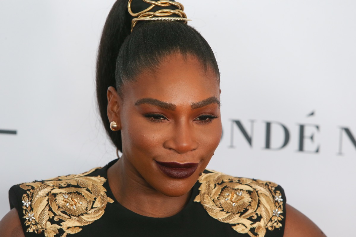 Serena Williams on red carpet in black and gold outfit