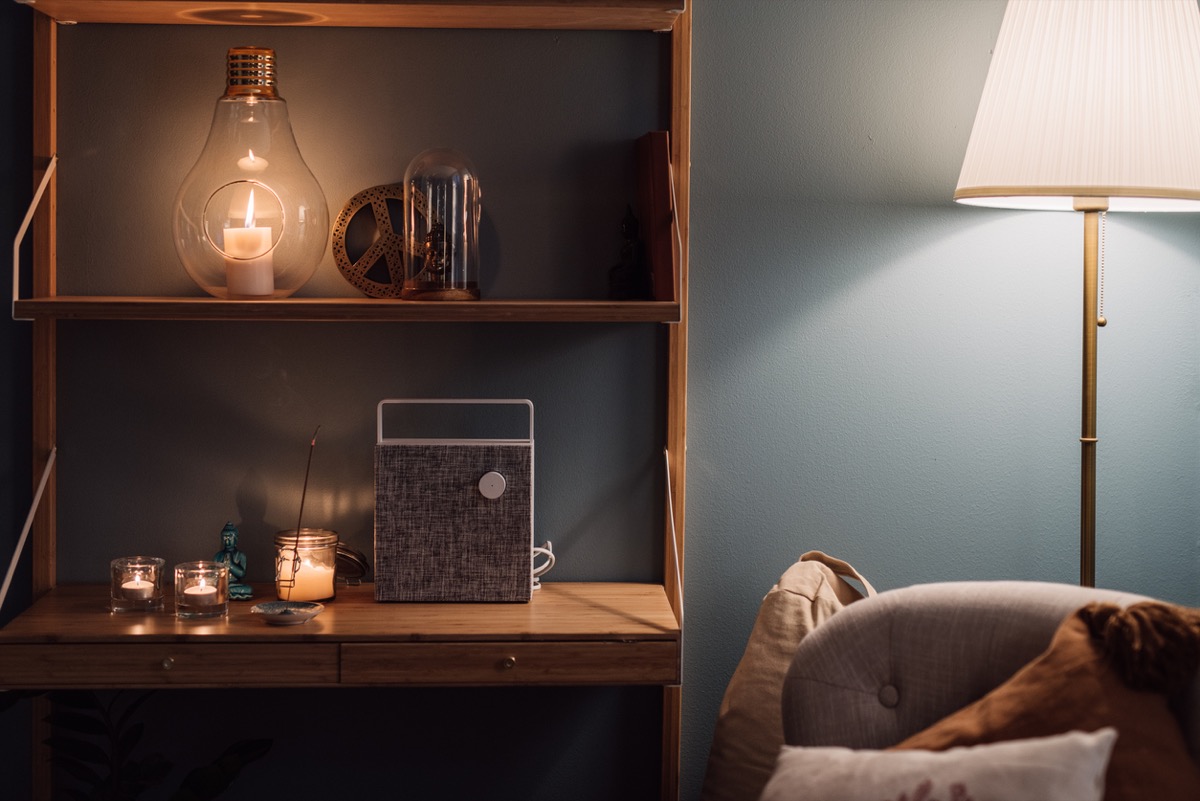 Cozy home interior shelf with candles and bluetooth wireless speaker