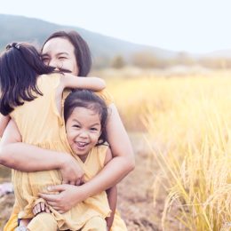 woman sitting outside with daughters, parenting tips